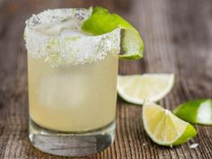 a margarita cocktail with limes and sugar on the rim