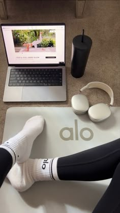 a person sitting at a desk with their feet on the mouse pad and headphones