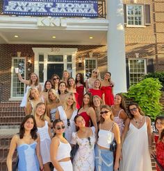 a group of women standing in front of a building