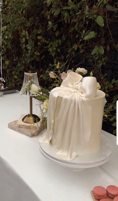 a wedding cake on a table with flowers and macaroons