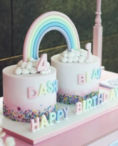 two birthday cakes decorated with rainbows and marshmallows