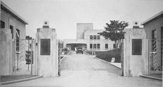 black and white photograph of an entrance to a building with gated in area next to it