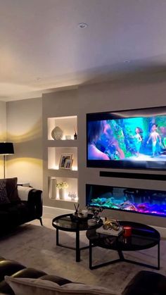 a living room filled with furniture and a large flat screen tv mounted to the wall