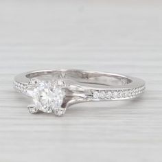 a white gold engagement ring with diamonds on the side and an oval cut diamond in the center