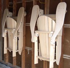 three wooden lawn chairs are lined up against the wall in front of a building under construction