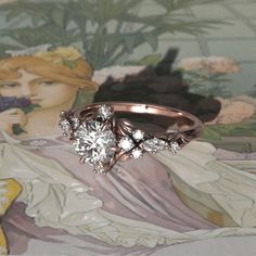 a diamond ring sitting on top of a table next to a flowered wallpaper