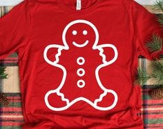 a red t - shirt with a white outline of a gingerbread man on it