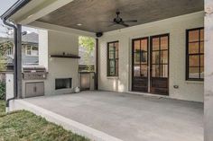 a covered patio with an outdoor fireplace and grill