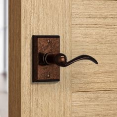 a door handle on a wooden door with a black handle and wood grained background