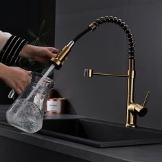 a woman is filling a glass bottle with water from the faucet in her kitchen