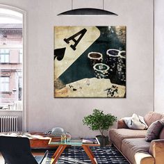 a living room filled with furniture and a painting hanging on the wall above a coffee table