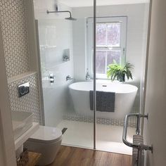 a bathroom with a toilet, sink and bathtub next to a window in it