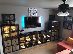 a living room filled with furniture and a flat screen tv on top of a entertainment center