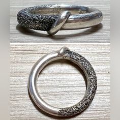 two silver rings sitting on top of a wooden table