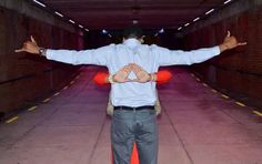 a man standing in a tunnel with his arms spread out and hands outstretched to the side