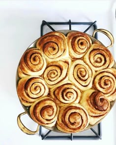 a pan filled with cinnamon rolls sitting on top of a stove