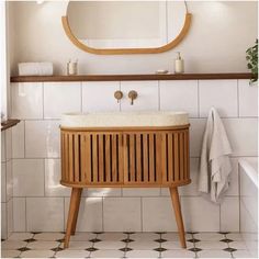 a bathroom with a sink, mirror and wooden cabinet