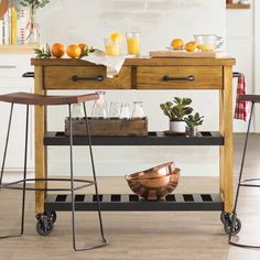 a kitchen island with two stools next to it and fruit on the counter top