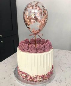 a white cake with pink frosting roses and a large mirror ball on the top