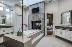 a large bathroom with a fireplace in the center