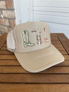 Tan trucker hat with 3 embroidered cowboy boots in the perfect neural fall colors One size fits most due to adjustable snap closure. Breathable mesh back. Embroidered Cowboy Boots, Kids Stickers, Linen Napkins, Fall Colors, Snap Closure, Cowboy Boots, Trucker Hat, Cowboy, Mesh