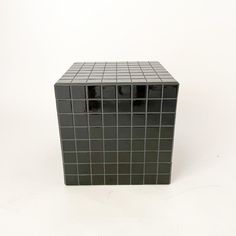 a black and white square shaped object on a white surface with no one around it