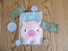 a pink piggy bank sitting on top of a wooden table next to some money