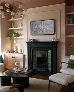 a living room filled with furniture and a fire place under a painting on the wall