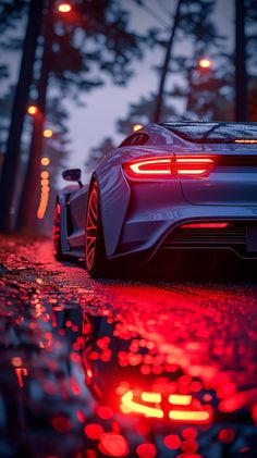 a white sports car parked on the side of a road at night with red lights