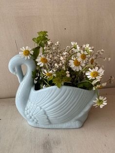 a blue vase filled with flowers on top of a table