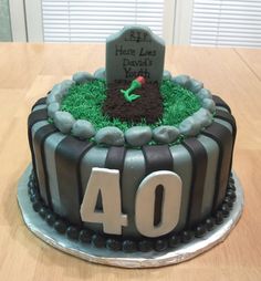 a decorated birthday cake with the number 40 on it's side and grass in the middle