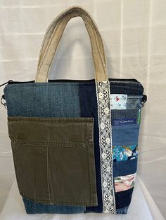 a handbag made out of jeans and fabric with a zippered pocket on the front