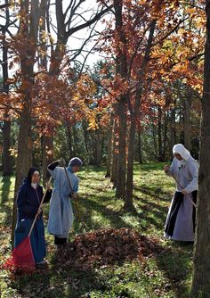 two women in medieval dress are cleaning the woods