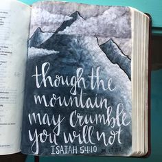 an open bible with the words though the mountain may crumble you will not written on it