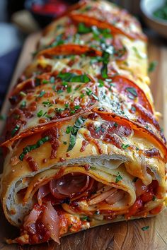 a close up of a long sandwich on a cutting board with other food items in the background