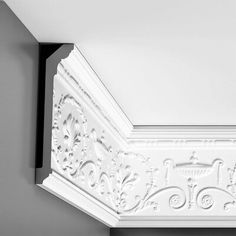 the corner of a room with a white coffert and decorative molding on the ceiling