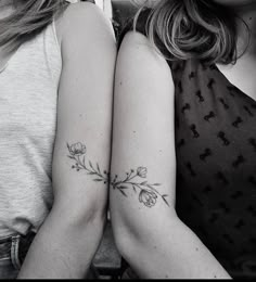 two women with matching tattoos on their arms