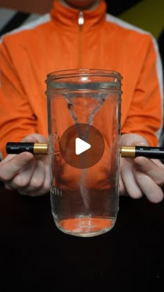 a person holding a glass with an hour in it