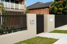 a house with a fence and number plate on it