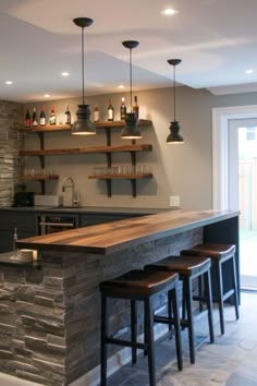 a kitchen bar with stools and bottles on the shelves