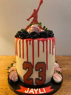 a decorated birthday cake with white and red icing