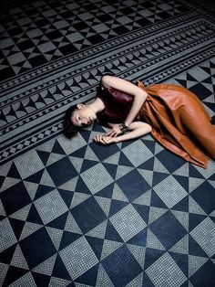 a woman is laying on the floor in a dress