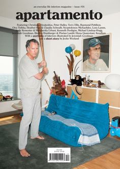 a man holding a baseball bat standing in front of a living room with a blue couch