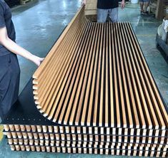 a woman standing in front of a wooden bench made out of plywood planks