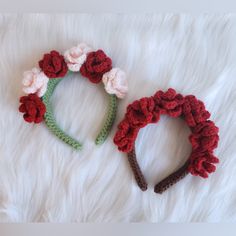 two crocheted flower headbands laying on top of a white furry surface