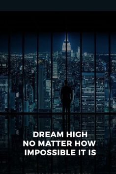 a man standing in front of a window with the words dream high no matter how impossible it