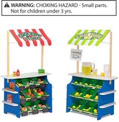 two children's toy food stands with signs on them and an advertisement for the store