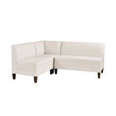 a white sectional couch sitting on top of a white floor next to a wooden leg chair