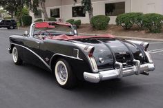 an old black car parked in front of a building