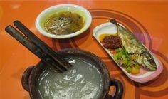 an orange table topped with plates and bowls filled with different types of food on top of it